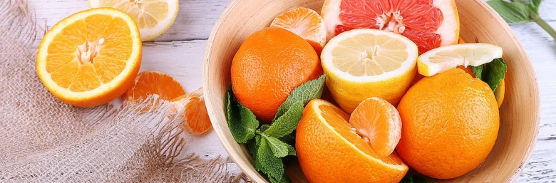 Čerstvá miska s citrony, pomeranči a hroznovou granátovinou.