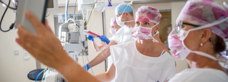 Tým lékařů v operační sále během chemoterapie nebo onkologického zákroku.