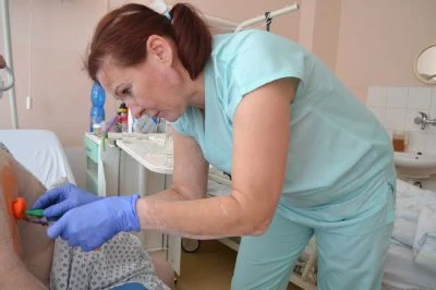 Sestra vkládá katétr do paže pacienta v nemocničním prostředí.