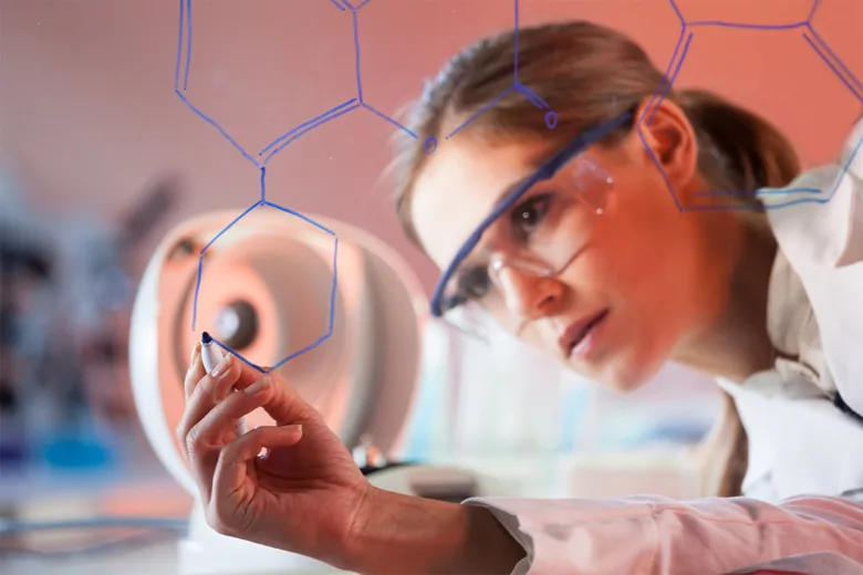 Vědkyně kreslí strukturu pteridinu na skleněnou desku v laboratoři.