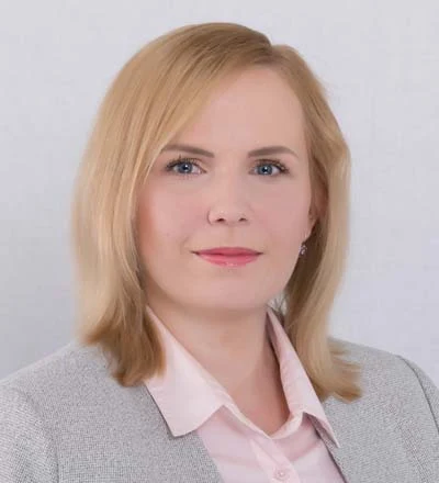 Profesionální portrét ženy v obleku na bílém pozadí.