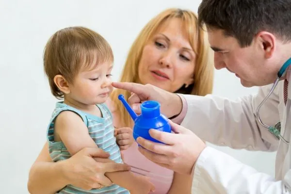 Lékař používá nosní zavlažování dítěti s matkou