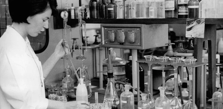 Žena v laboratoři pracuje s chemickým vybavením.