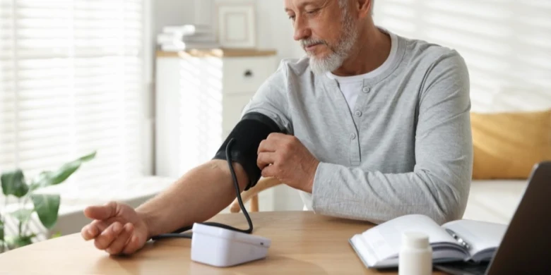 Elderly man measuring blood pressure