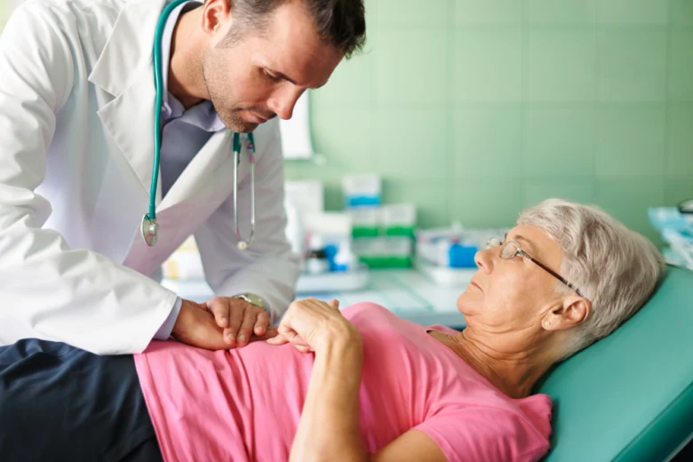 Lékař vyšetřuje starší pacientku na klinice při podezření na chronický zánět slepého střeva.