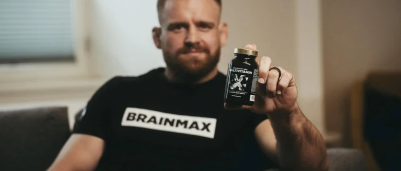 Muž drží láhev vitamínů pro mozek v ruce.