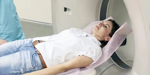 Žena leží v magnetické rezonanci pro vyšetření mozku.