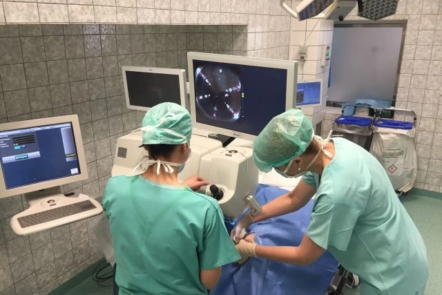 Dva lékaři provádějí operaci s monitorováním vnitřních orgánů.