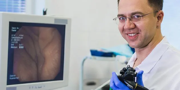 Lékař s endoskopem u monitoru zobrazujícího střevní vyšetření.