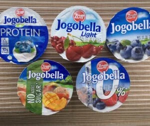 Sada jogurtů Jogobella s různými příchutěmi a výživovými údaji.