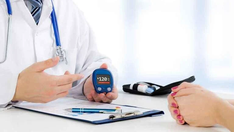 Lékař ukazuje pacientovi hodnotu glykovaného hemoglobinu na přístroji.