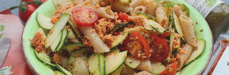 Pasta s cuketou a rajčaty na zeleném talíři