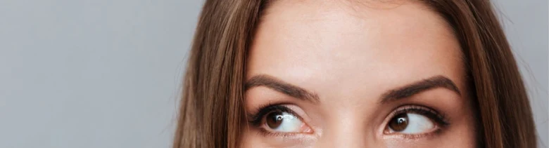 Žena s hnědýma očima hledícími nahoru na neutrálním pozadí.