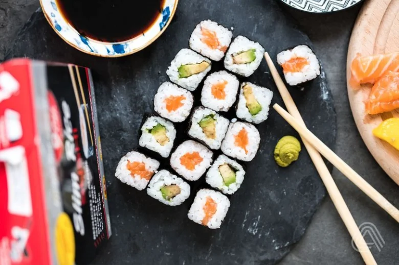 Sushi s lososem na tmavém podkladu pro článek o kaloriích.