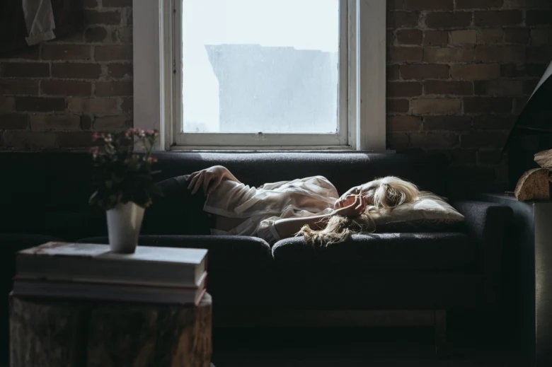 Tired woman sleeping on couch