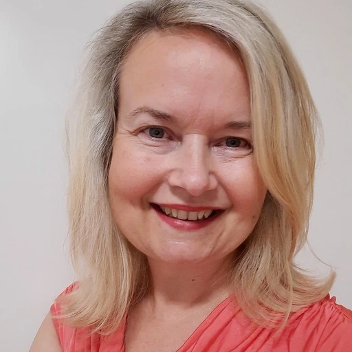 Usměvavá žena s blond vlasy v oranžovém tričku.
