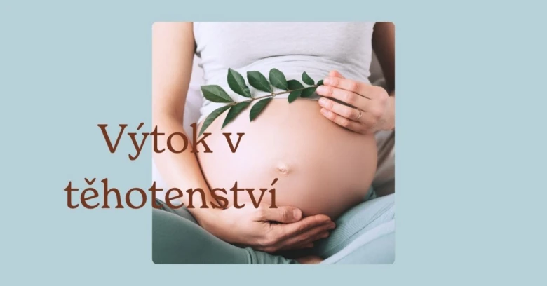 Těhotná žena drží zelené větvičky na svém břiše.