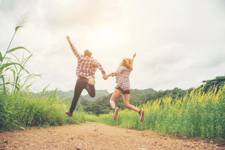 Couple jumping in field