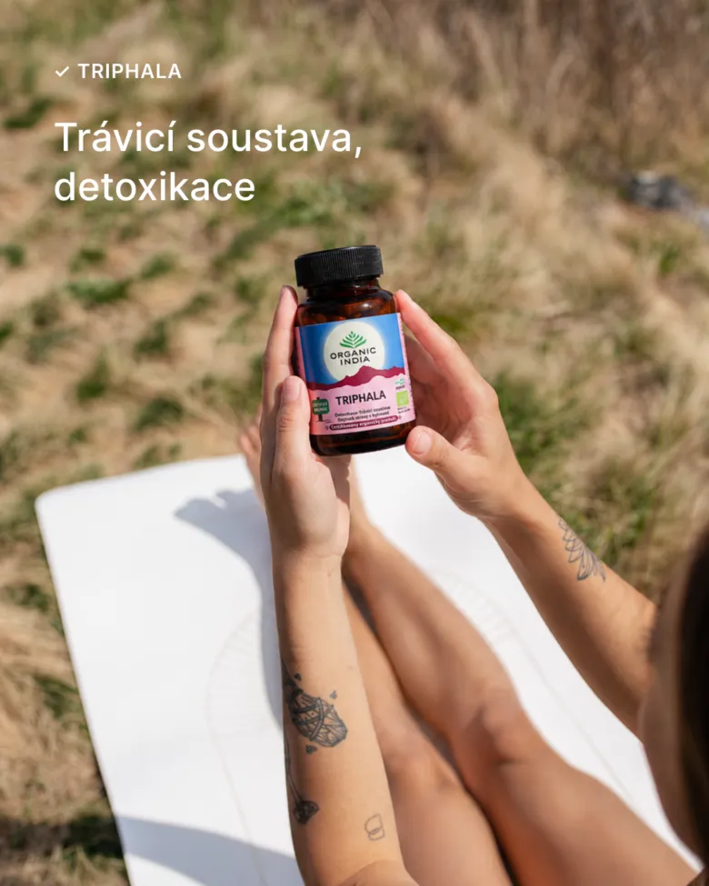 Doplněk s triphalou v ruce na venkovní pozadí.