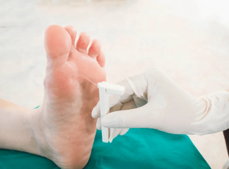 Lékař vyšetřuje chodidlo pomocí diagnostického nástroje.