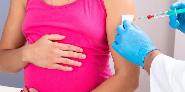 Těhotná žena dostává očkování proti černému kašli.