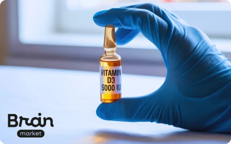 Ruka drží ampulku vitamínu D3 s dávkou 5000 ME.