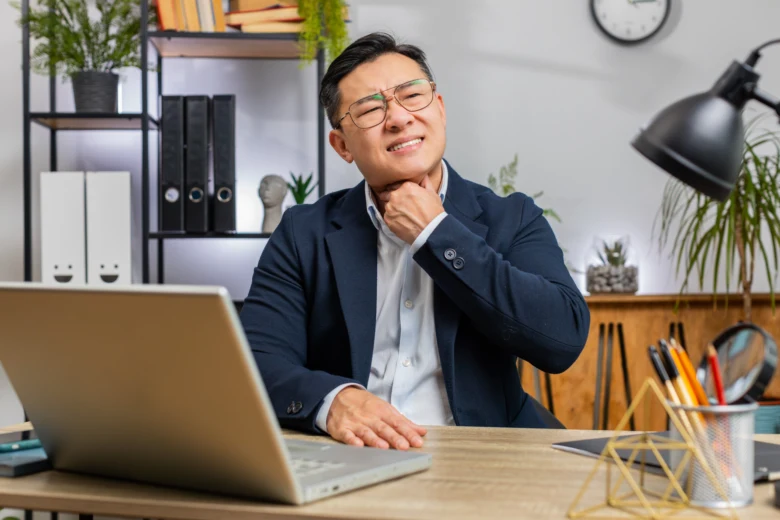 Man with sore throat at desk