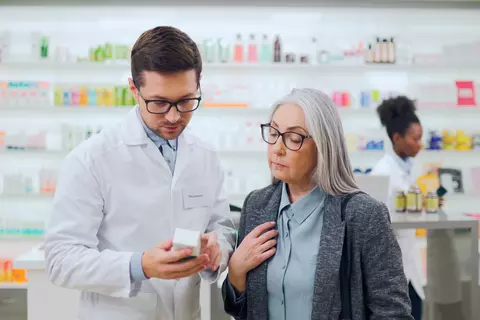 Farmaceutka vysvětluje léky pacientce v drogerii.