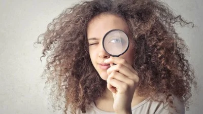Žena s lupou hledá informace o intimní oblasti.