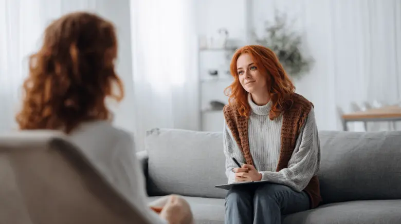 Terapeutka naslouchá klientovi během psychoterapie.