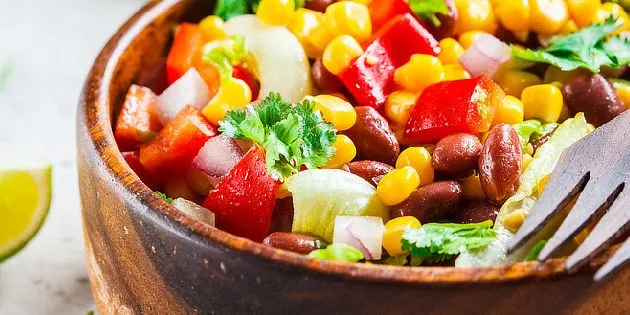 Dřevěná miska s barevnou zeleninovou salátou pro žlučníkovou dietu.