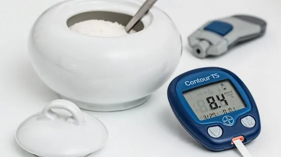 Měřič glukózy v krvi s nádobou na cukr.