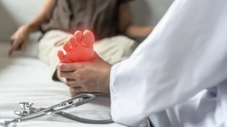 Lékař vyšetřuje bolestivou nohu pacienta s příznaky neuropatie.