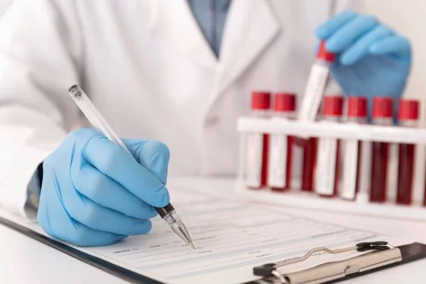 Lékař zapisuje výsledky krevních vzorků pro diagnostiku sepse.