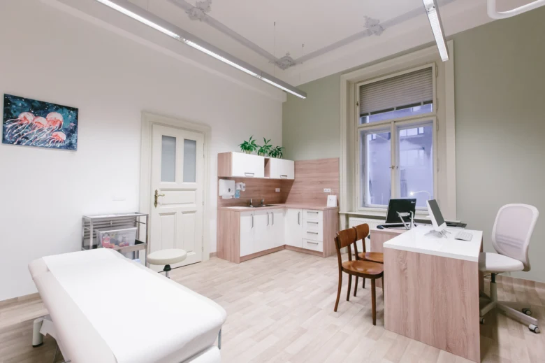 Moderní lékařský pokoj s vyšetřovacím stolem a pracovištěm pro Bechtěrevovu nemoc.