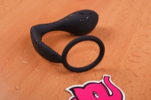 Černý silikonový masážní přístroj pro prostatu na dřevěné ploše.