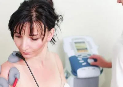 Žena podléhá elektroterapii ramene v konstantinových lázních.