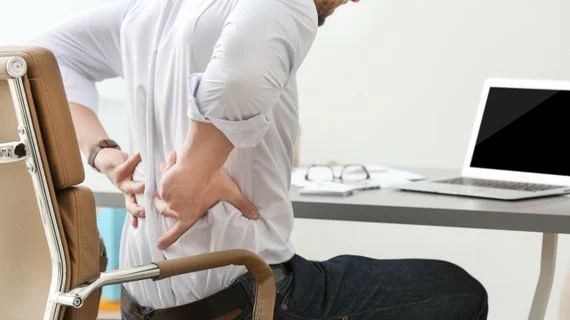 Man holding lower back in pain