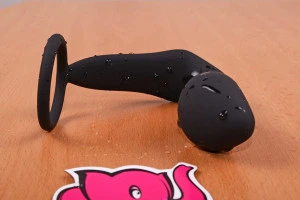 Černý silikonový hračka pro masáž prostaty na dřevěném povrchu.