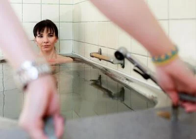 Žena v bazénu s hydromasáží při lázeňské léčbě.